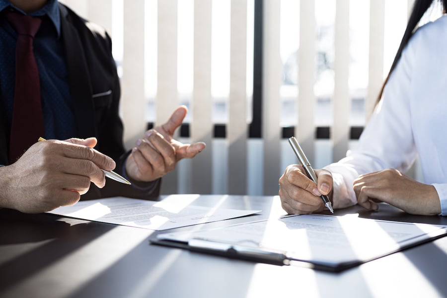 The IT expert and the customer are signing an agreement with their IT company, accepting the terms and benefits. 