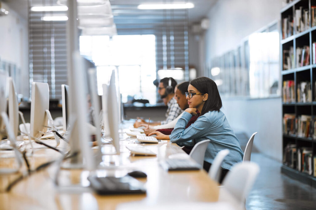 A woman sitting at a row of computers