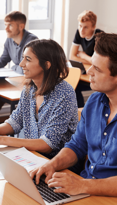 Mature Students Sitting At Desks In Adult Education Class