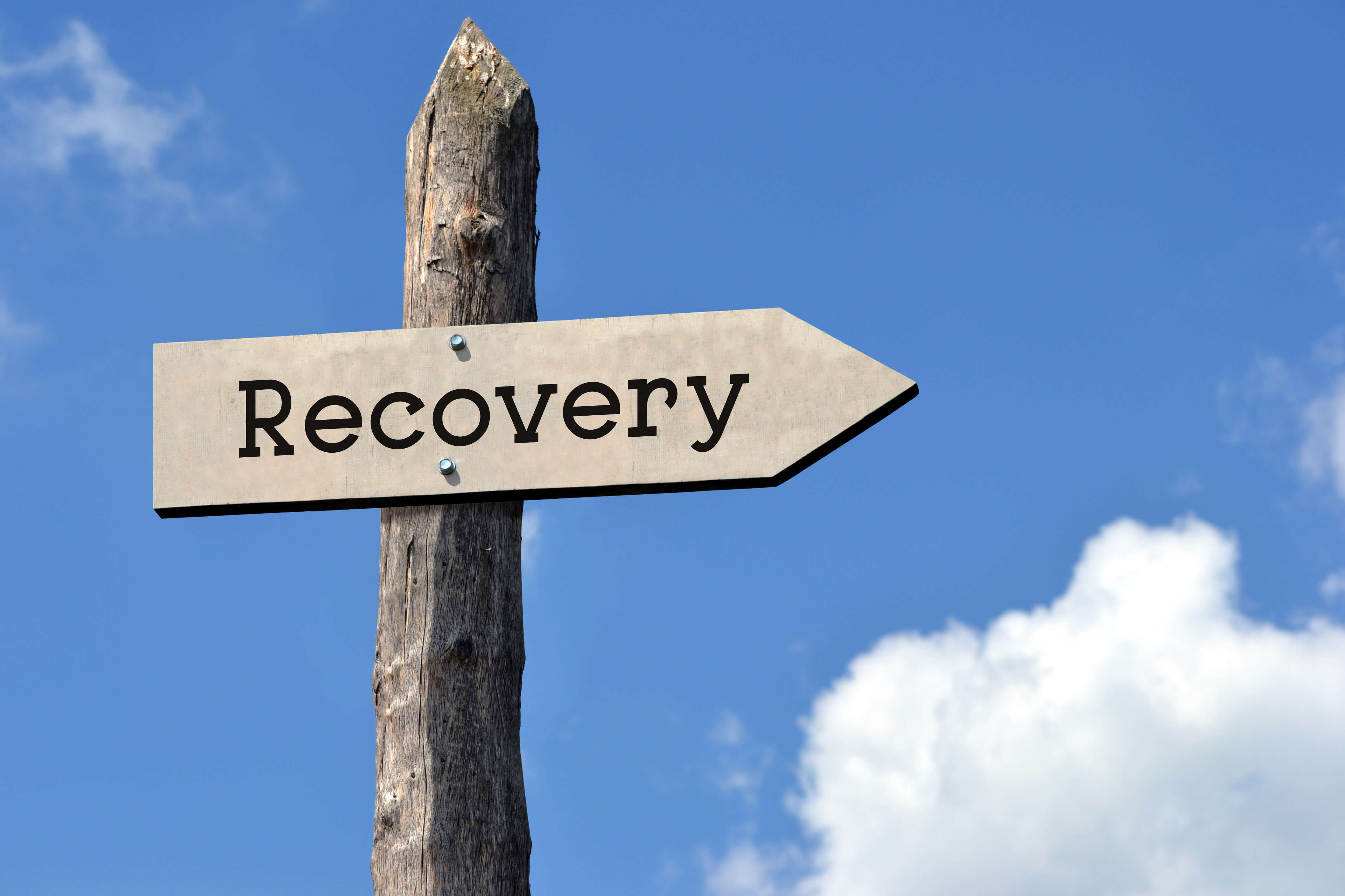 Recovery - wooden signpost with one arrow, sky with clouds