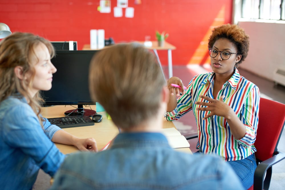 Unposed group of creative business people in an open concept office brainstorming their next project.